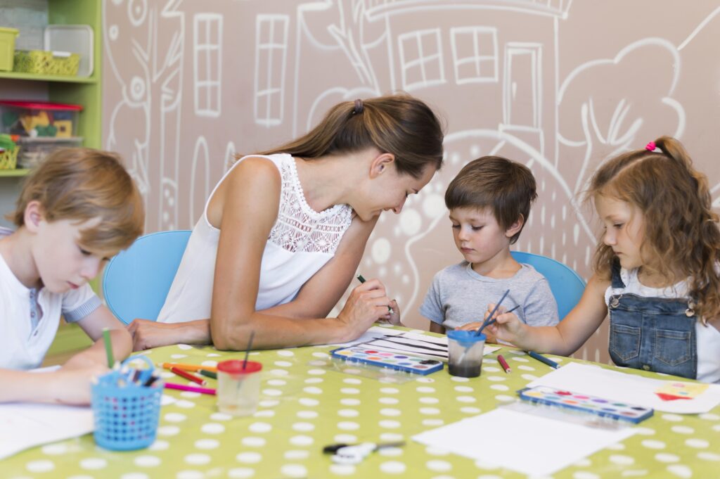 teacher-helping-kid-paint